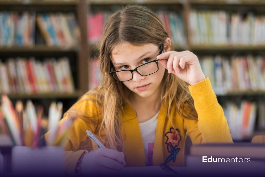 Girl completing a non verbal reasoning 11 plus revision exercise in a library