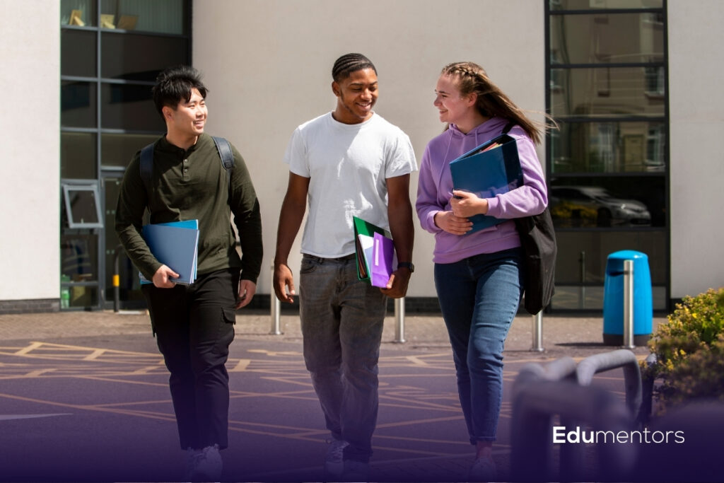 A Levels students walking together outside college with folders and study materials
