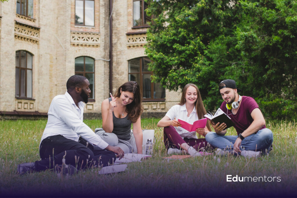 Four students studying outdoors with books and notes, illustrating the Arden University student guide.